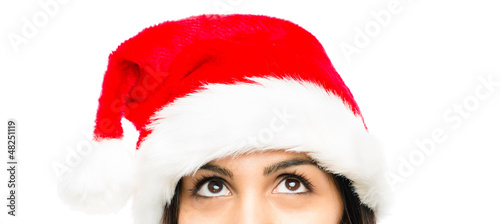 Close up of pretty woman wearing christmas hat looking up isolat
