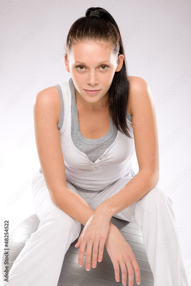 Sporty young woman sitting on fitness ball Sporty young woman sitting on fitness ball