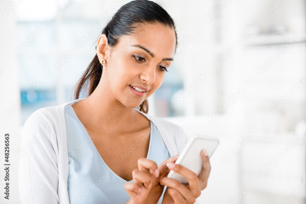 Obraz premium Beautiful Indian woman sending text message mobile phone happy