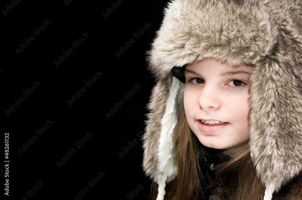 An image of a young girl wearing a furry hat on black background An image of a young girl wearing a furry hat on black background