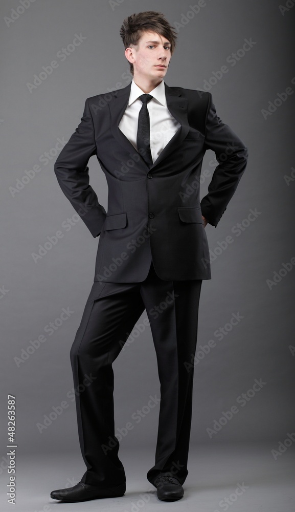 young businessman black suit casual tie on gray background young businessman black suit casual tie on gray background