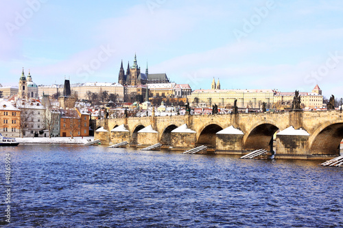 Snowy Prague gothic Castle with Charles Bridge in the sunny Day © Kajano