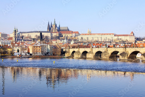 Snowy Prague gothic Castle with Charles Bridge in the sunny Day