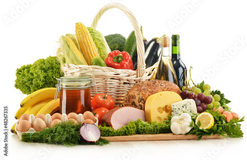 Composition with groceries in wicker basket on kitchen table