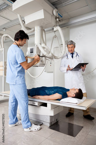 Radiologists Performing X-ray On Patient