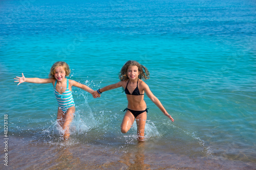 children girls friends running together in the beach shore