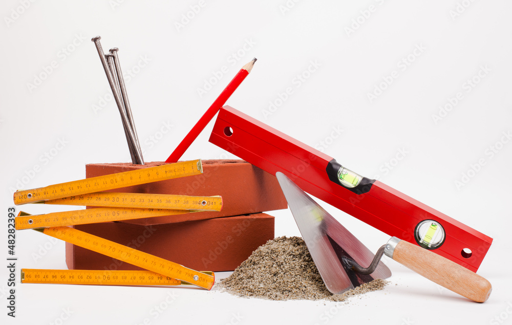 sand pile, bricks and mason tools