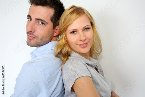 Couple standing back to back on white background