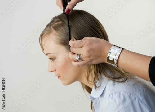 Fotografi Coiffeuse coiffant une jeune femme