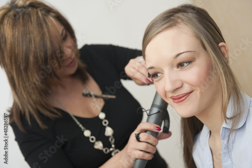 Fotografi Coiffeuse coiffant une jeune femme