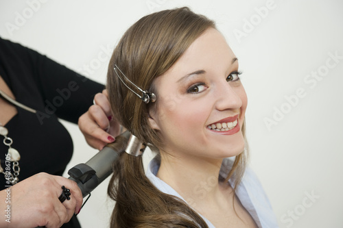 Fotografi Coiffeuse coiffant une jeune femme