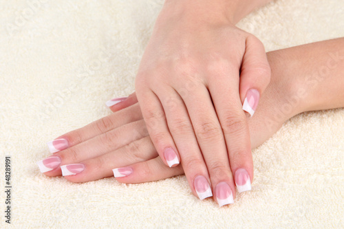 Woman hands with french manicure on towel