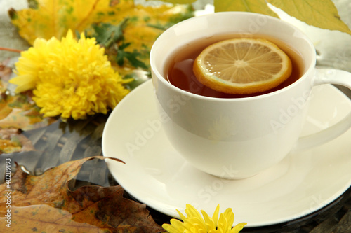 cup of hot drink and autumn leaves, close up