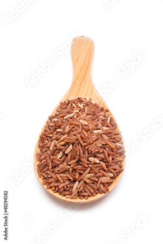 Brown rice with wooden spoon isolated on white background.