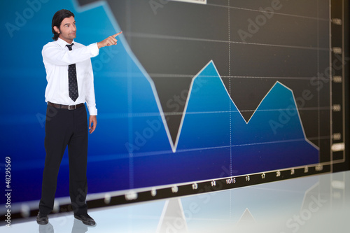 tall dark-haired man standing before graph