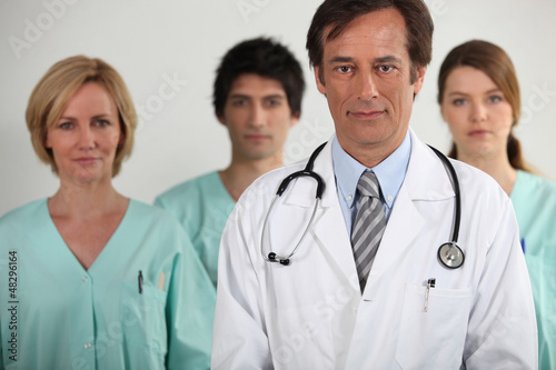 A doctor and three nurses behind him, all looking at us.