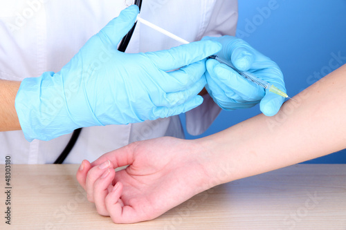 vaccine injection in hand on blue background