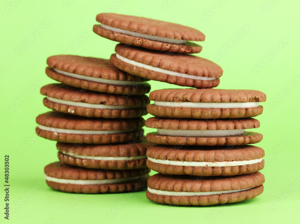 Chocolate cookies with creamy layer on green background Chocolate cookies with creamy layer on green background