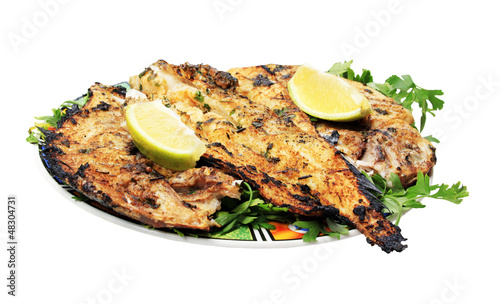 Grilled fish with greens on the plate - isolated on white backgr