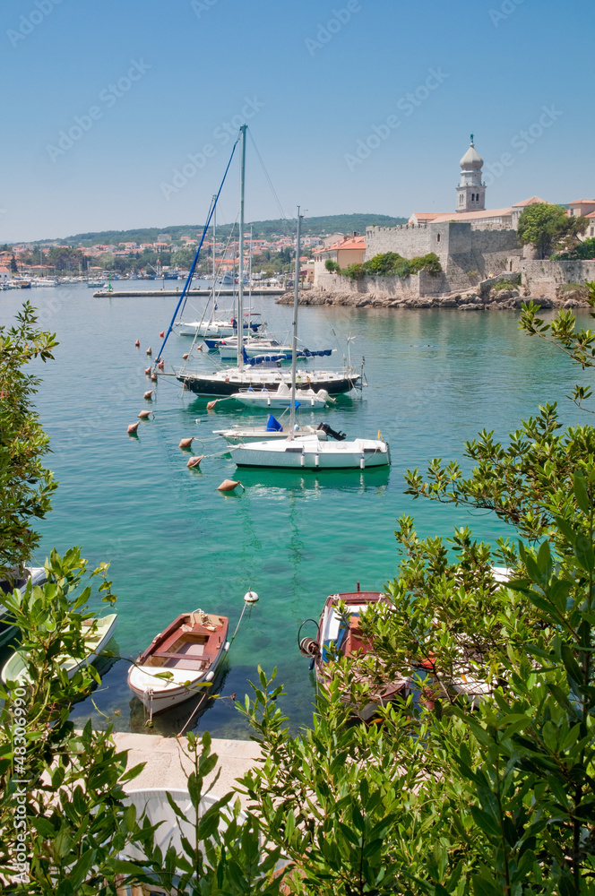 Fototapeta premium Boats on little port beside Krk old town view with vegetation -