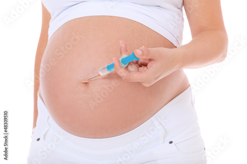 Schwangere Frau mit Spritze in der Hand