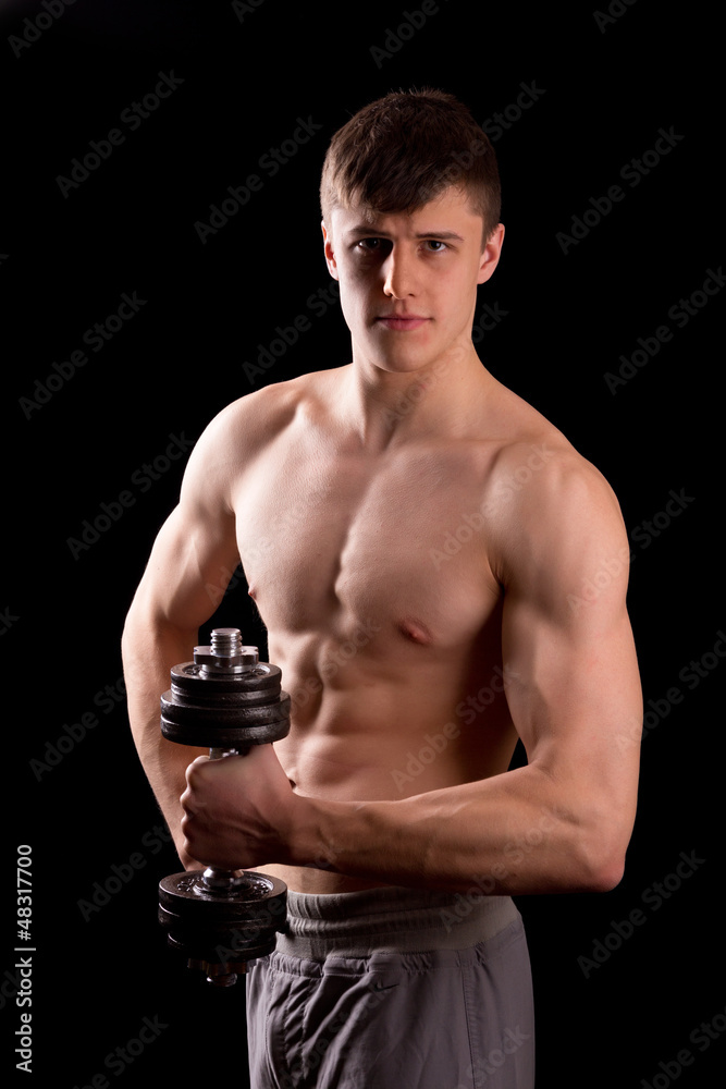 Naklejka premium Young muscular man training with dumbbell