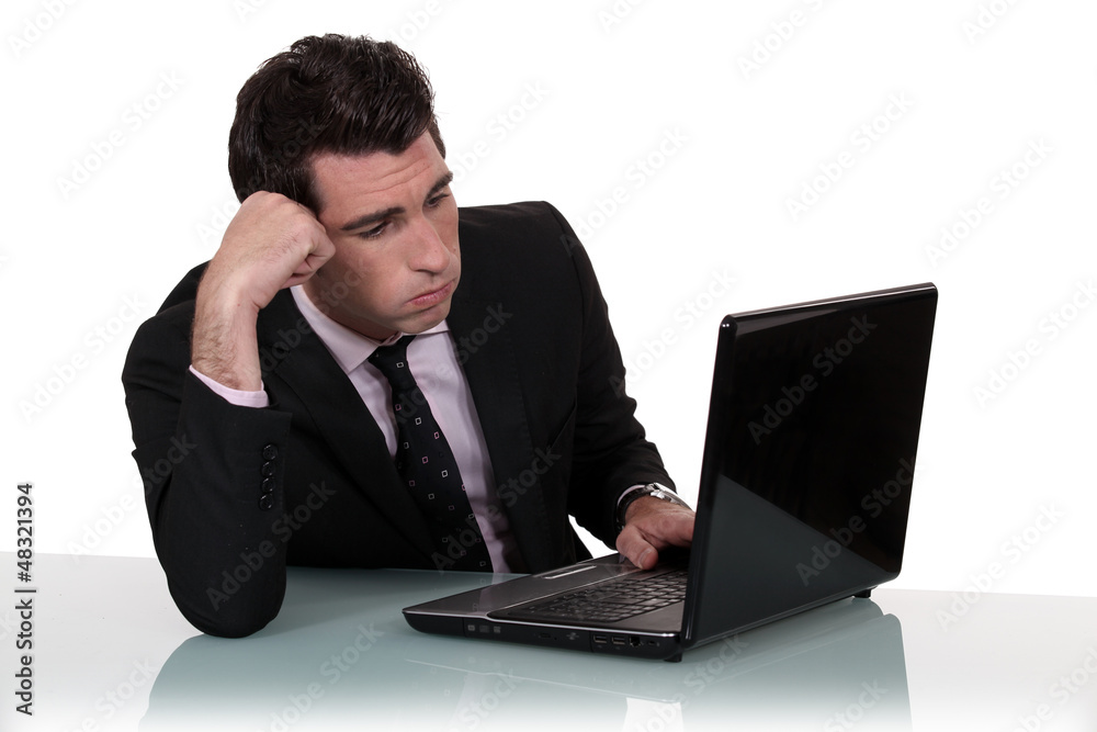 Annoyed businessman working on his laptop Annoyed businessman working on his laptop