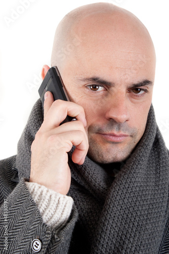 Man with coat and scarf on the phone.