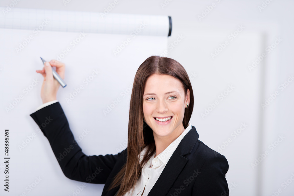 junge geschäftsfrau schreibt an das flipchart junge geschäftsfrau schreibt an das flipchart