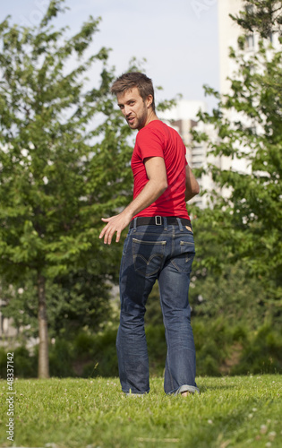 smiling young man walking and turning around