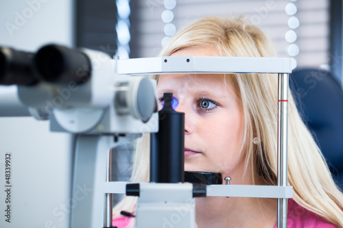 Pretty, young female patient having her eyes examined