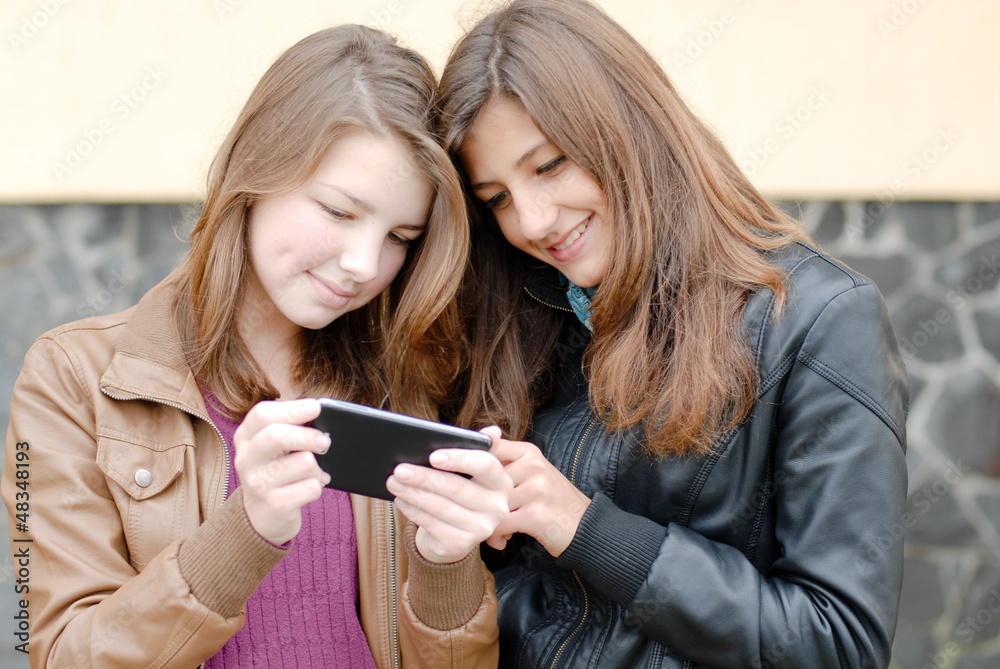 Two teen girls looking on tablet pc Two teen girls looking on tablet pc