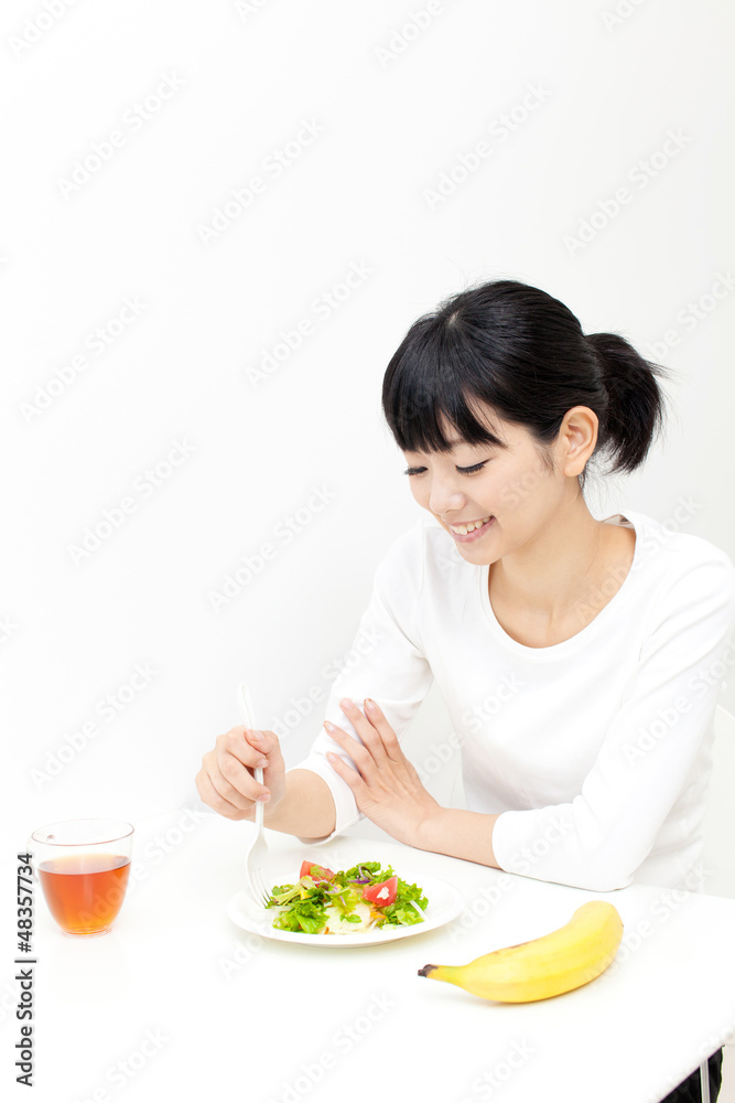 a young asian woman eating salad a young asian woman eating salad