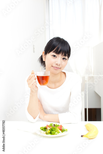 a young asian woman eating salad