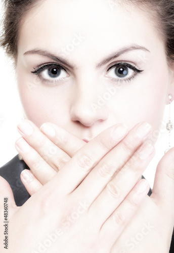 portrait of excited business woman covering her mouth by the han
