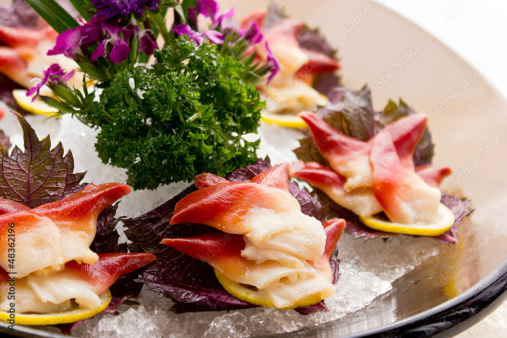 An assortment of different types of sashimi served on a delicate