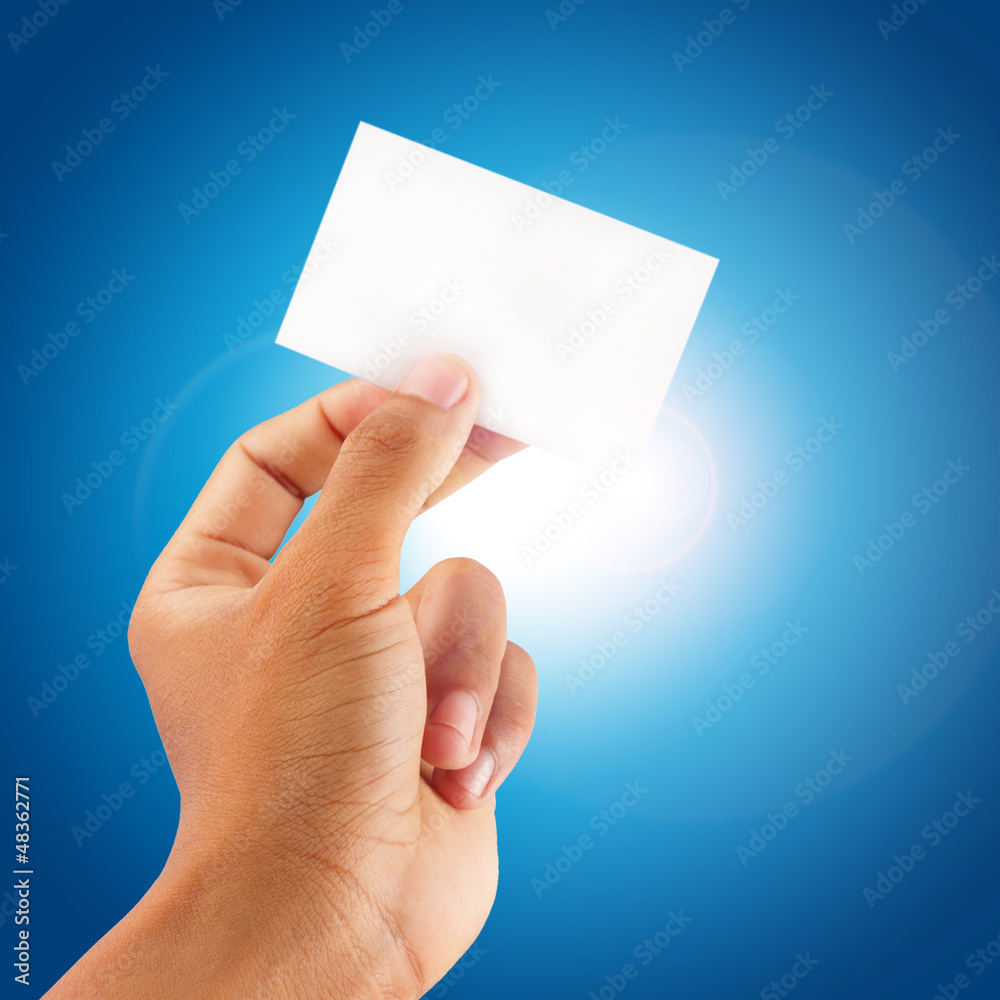 close up hand showing a blank card with blue sky background close up hand showing a blank card with blue sky background