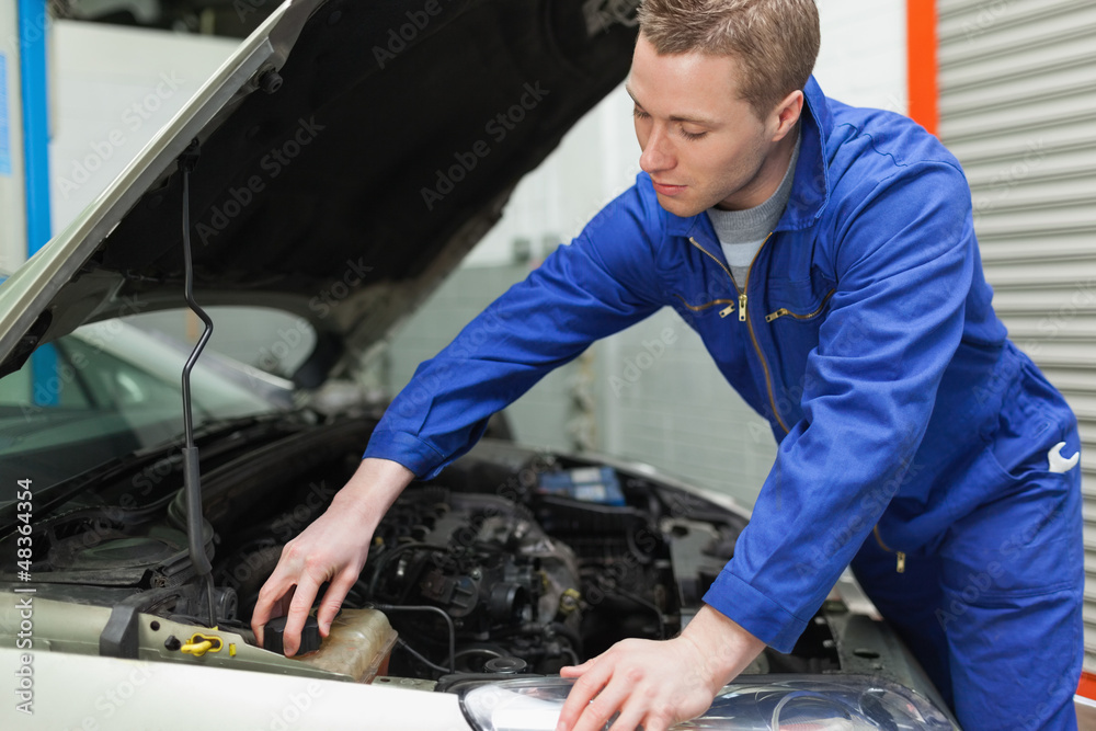 Mechanic closing the lid of windshield washer tank Mechanic closing the lid of windshield washer tank