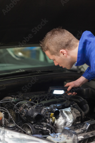 Repairman examining car engine