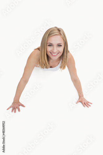 Portrait of happy young woman doing push-ups