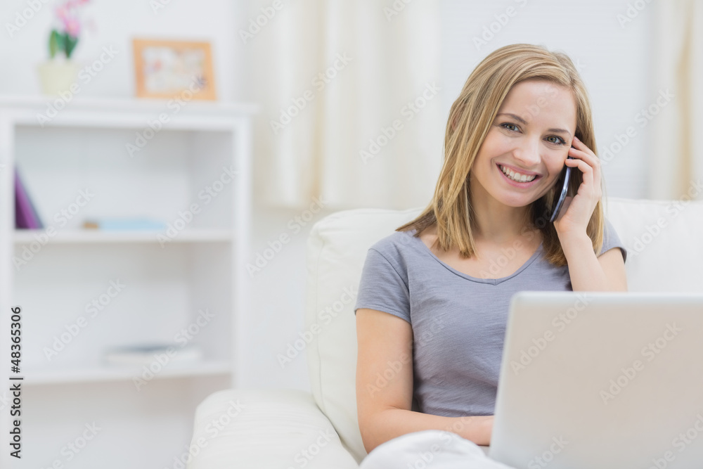 Portrait of woman using laptop and cellphone at home Portrait of woman using laptop and cellphone at home