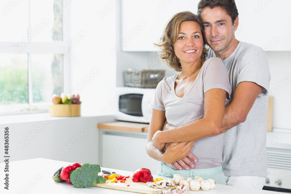 Wife and husband embracing in the kitchen