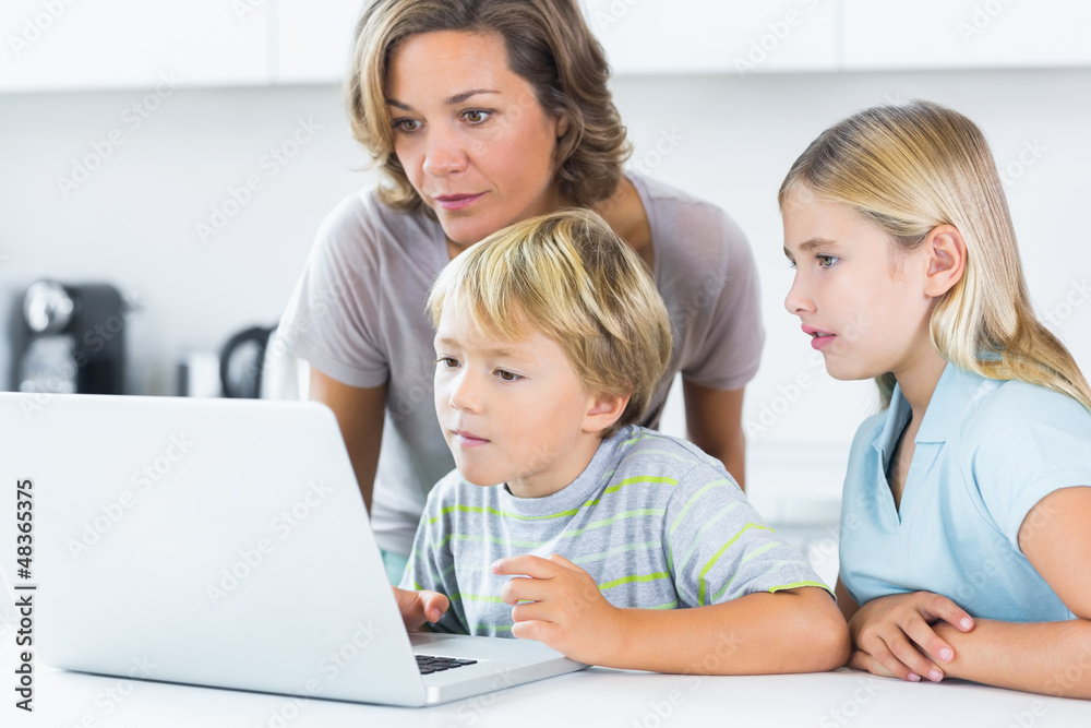 Mother and children using laptop
