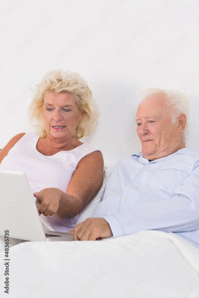 Focused aged couple using a laptop Focused aged couple using a laptop
