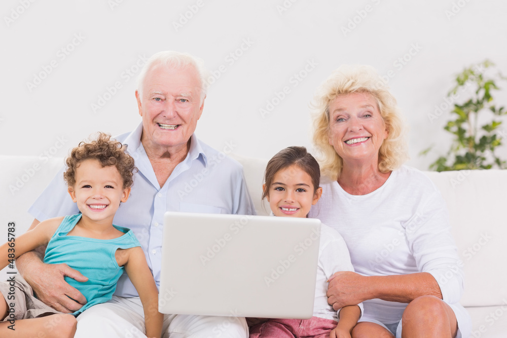 Smiling grandparents with children using a pc Smiling grandparents with children using a pc