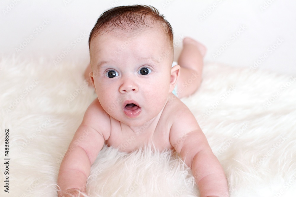 The surprised baby lies on a stomach on a fur plaid (3,5 months) The surprised baby lies on a stomach on a fur plaid (3,5 months)
