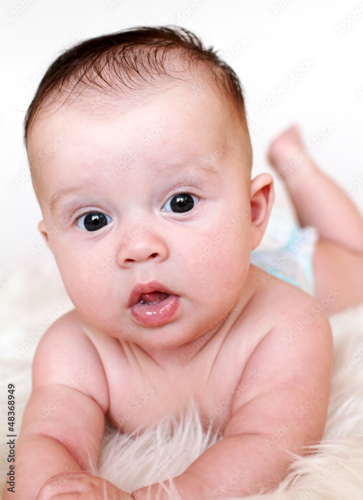 The happy baby lies on a stomach on a fur plaid (3,5 months) The happy baby lies on a stomach on a fur plaid (3,5 months)