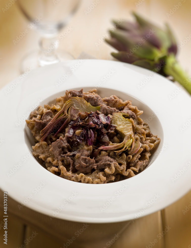 integral pasta with artichoke and chicory, selective focus integral pasta with artichoke and chicory, selective focus
