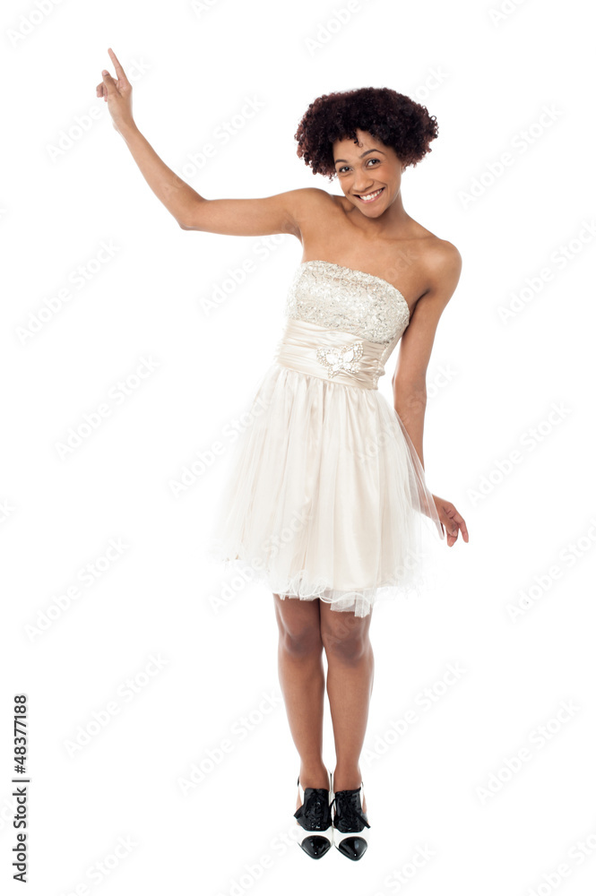 Naklejka premium Joyous fashion female model pointing upwards