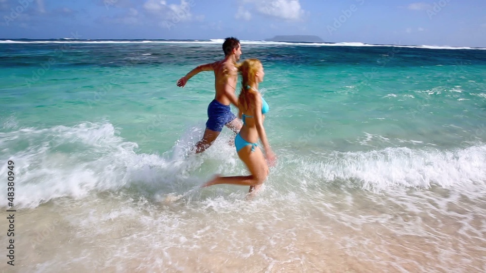 Couple running on sandy beach in caribbean island Couple running on sandy beach in caribbean island